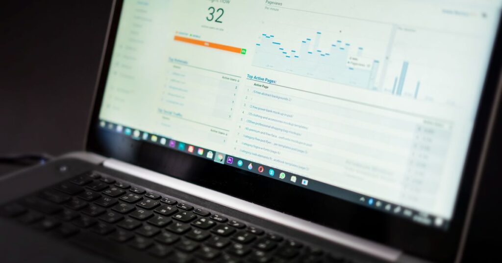 Laptop screen showing a real-time web analytics dashboard with active users and pageview charts.