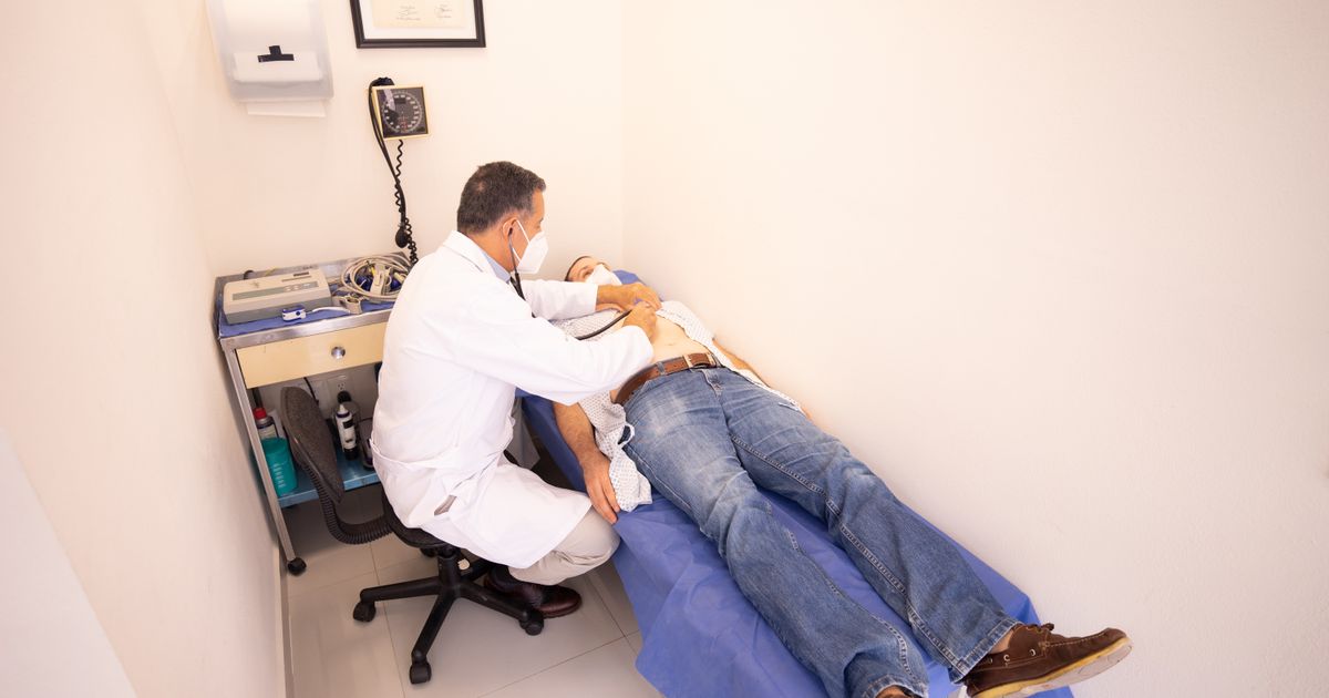 Doctor consulting a patient in a clinic examination room, illustrating healthcare marketing in Singapore.