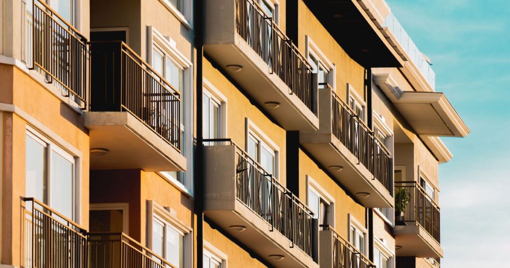Modern high-rise residential apartment building with balconies, illustrating property marketing in Singapore.