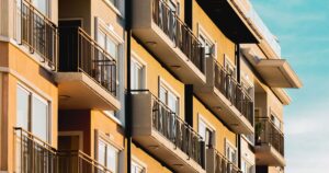 Modern high-rise residential apartment building with balconies, illustrating property marketing in Singapore.
