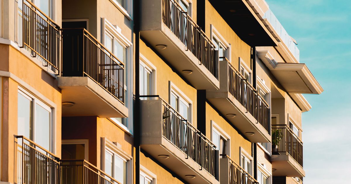 Modern high-rise residential apartment building with balconies, illustrating property marketing in Singapore.