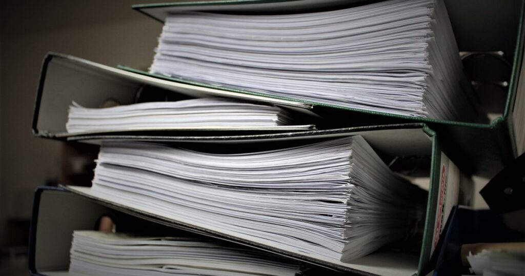 Stacked binders filled with documents, representing duplicate content across pages
