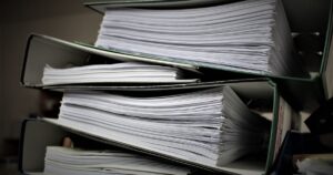 Stacked binders filled with documents, representing duplicate content across pages