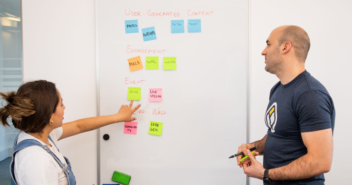 Two professionals mapping out a plan on a whiteboard, representing Google Ads account structure