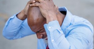 Frustrated businessman sitting with a laptop, representing a Google Ads campaign that is not converting