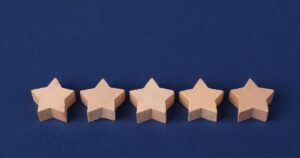 Five wooden stars on a blue background, representing Google Ads Quality Score ratings