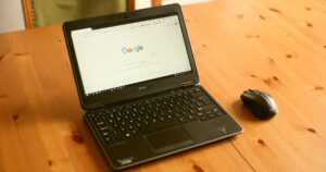 Laptop and mouse on a wooden desk with the Google homepage open, representing Google Ads in Singapore