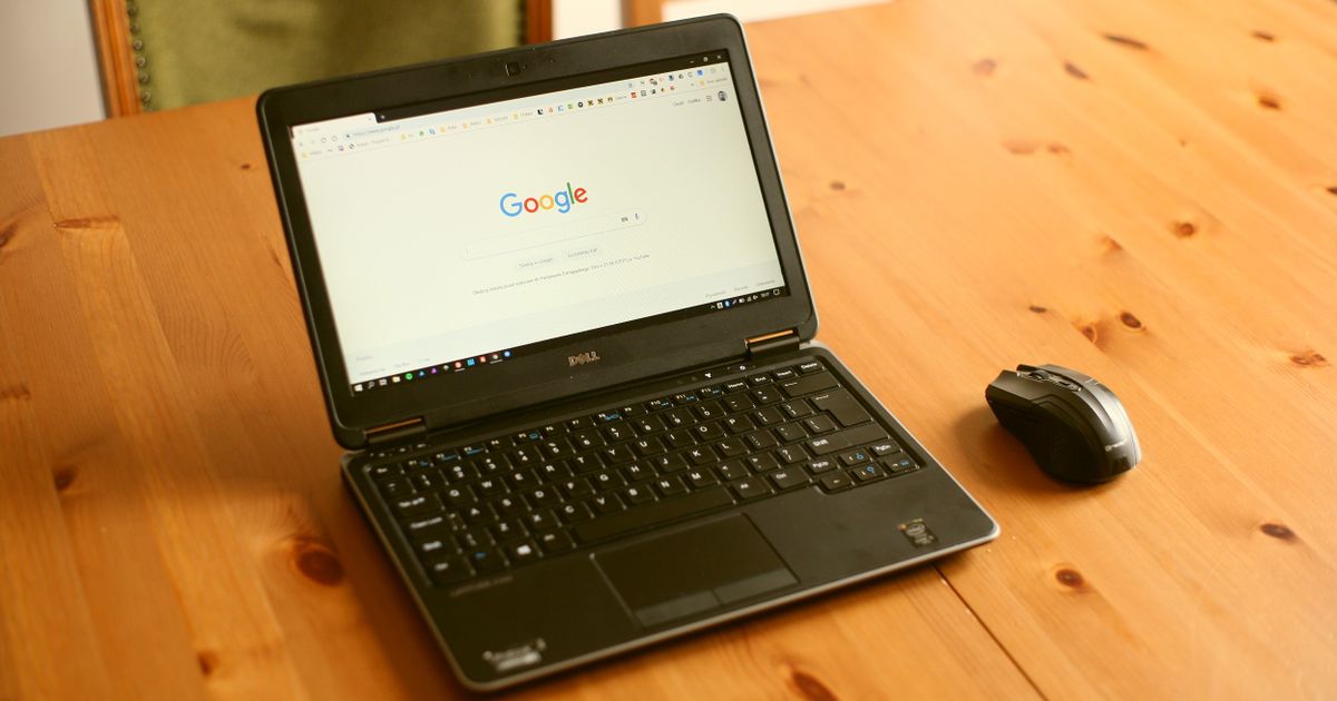 Laptop and mouse on a wooden desk with the Google homepage open, representing Google Ads in Singapore