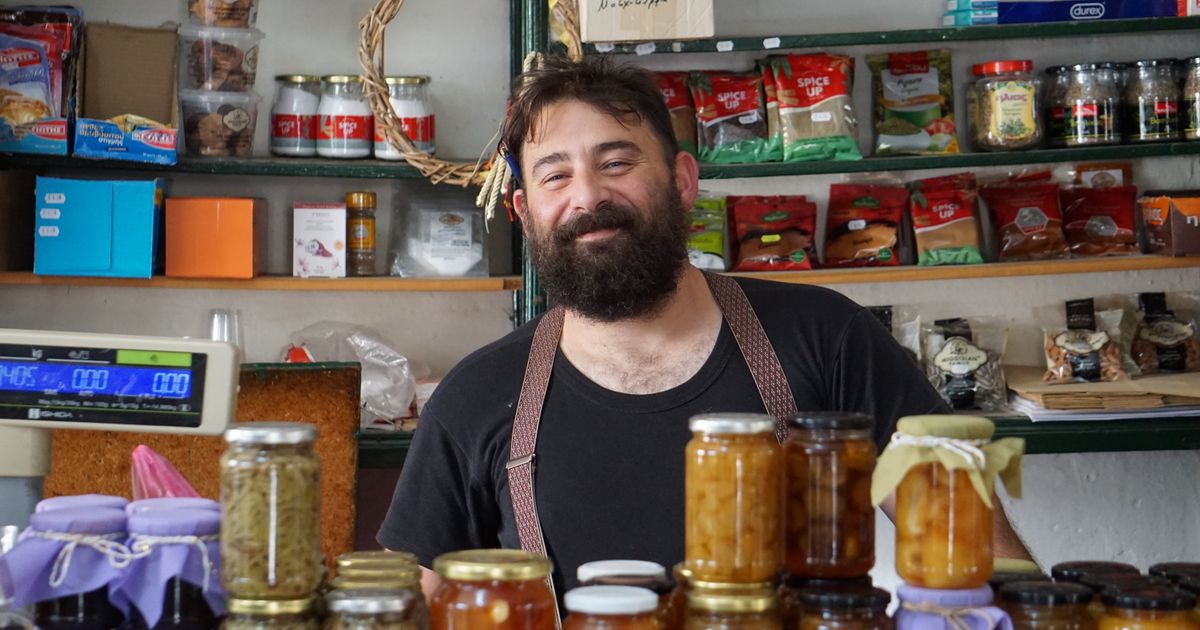 Shopkeeper standing behind shelves in a small local store, representing a Google Business Profile listing