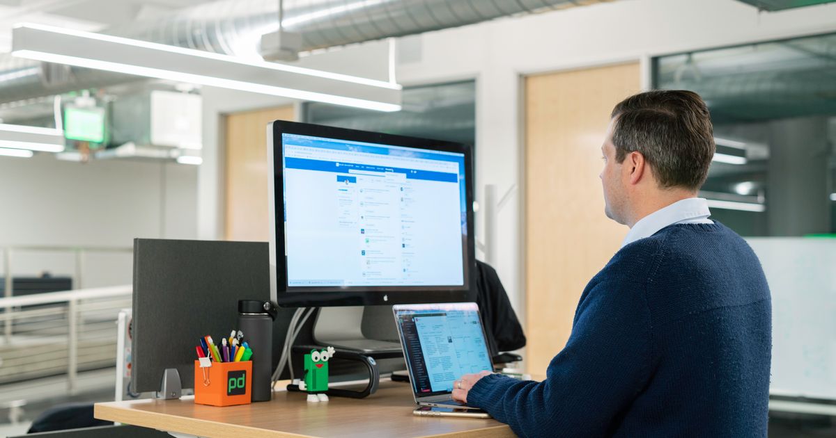 Business professional working on a laptop at a standing desk in a modern office, using LinkedIn for B2B outreach.