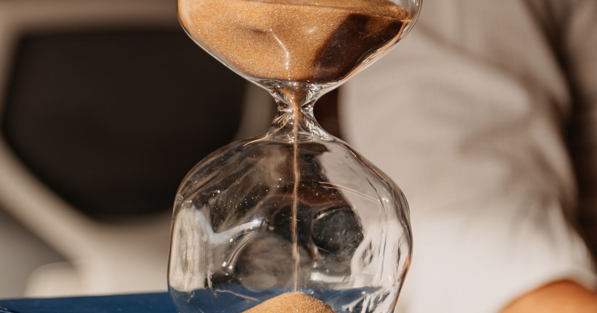 Hourglass resting on books in a modern office, representing how long SEO takes to work
