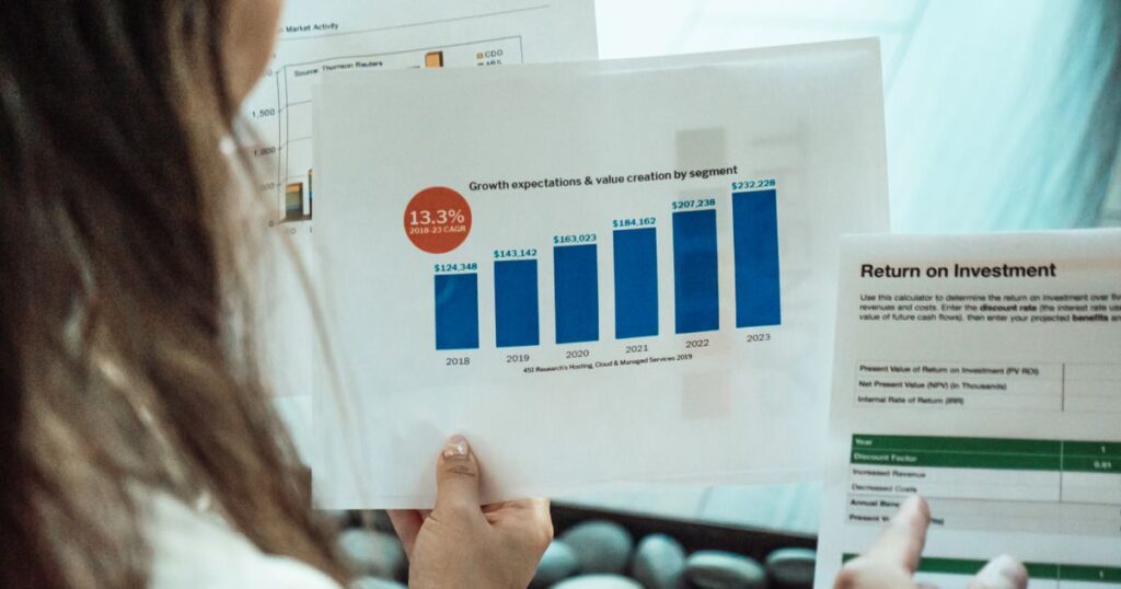 Person analysing financial graphs and return on investment reports, representing SEO ROI