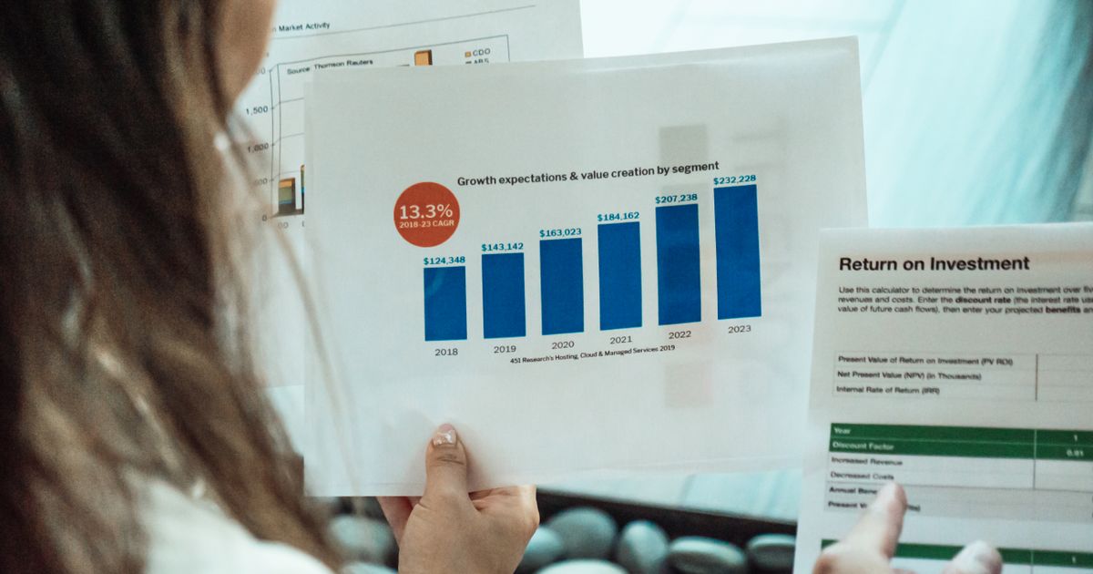 Person analysing financial graphs and return on investment reports, representing SEO ROI