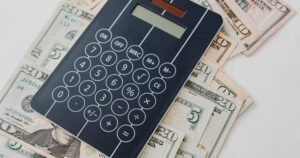 Calculator resting on banknotes, representing the cost of Meta advertising
