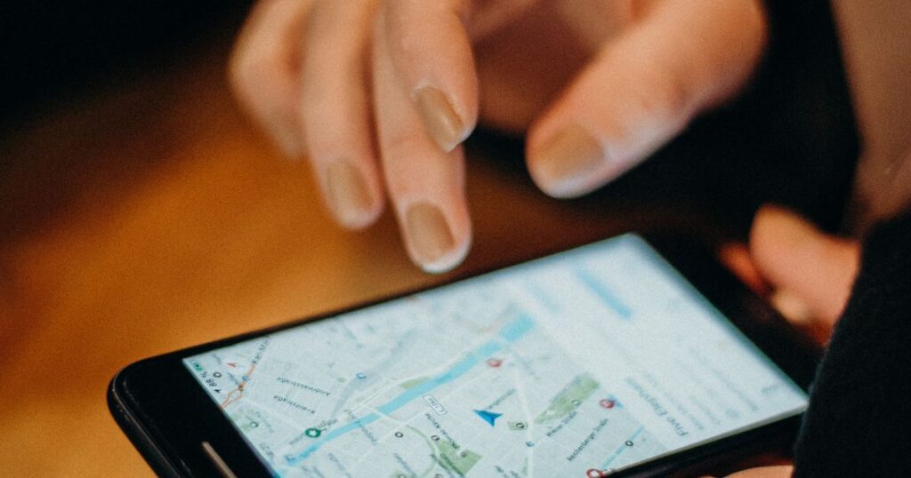 Hand holding a smartphone showing a map, representing near me searches on mobile