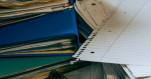 Organised desk with sorted stacks of paper and folders, representing filtering traffic with negative keywords