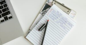 Organised to-do list on a clipboard beside a laptop, representing an on-page SEO checklist