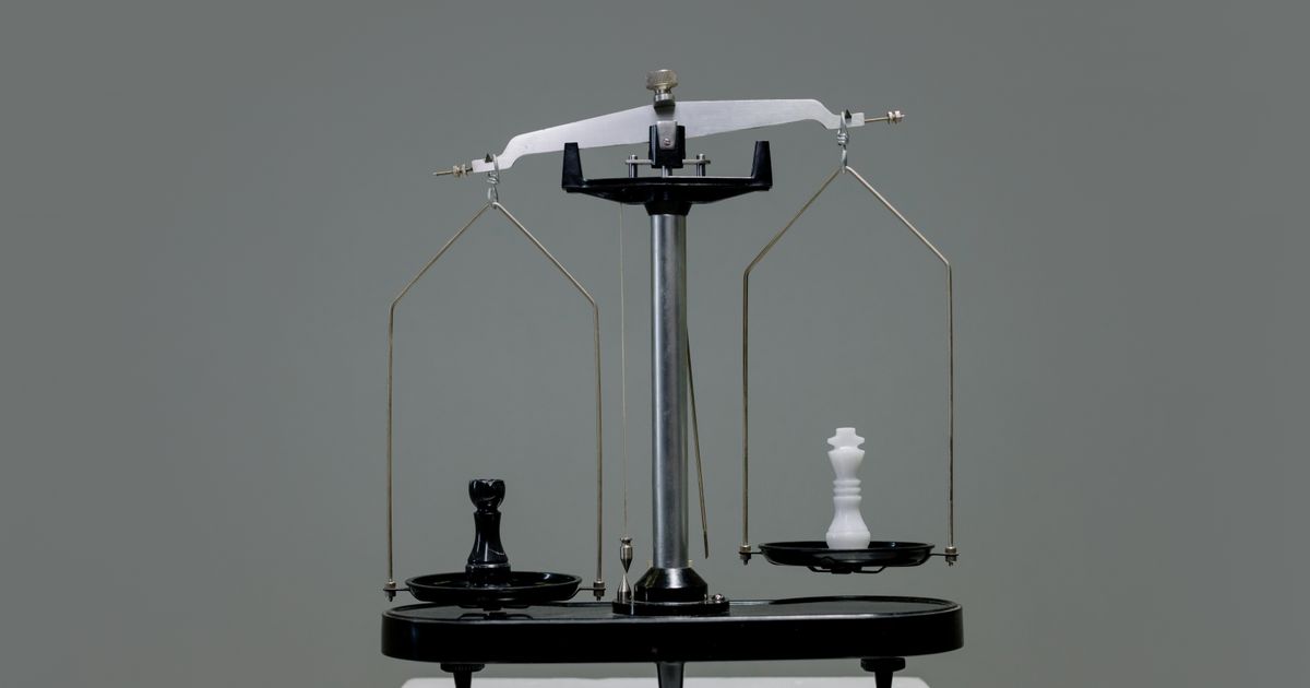 Chess pieces balanced on a scale, representing the choice between SEO and Google Ads