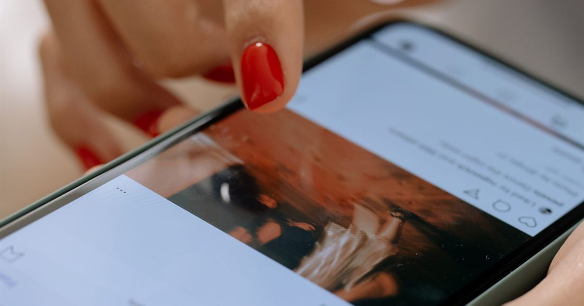 Person scrolling a short-form video social feed on a smartphone