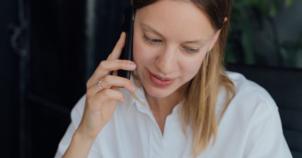 Business owner taking an enquiry phone call on a mobile in an office