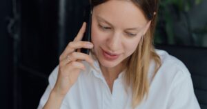 Business owner taking an enquiry phone call on a mobile in an office