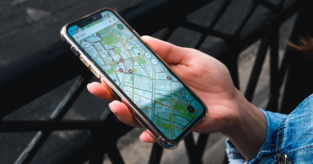 Hand holding a smartphone showing a city street map with business location pins