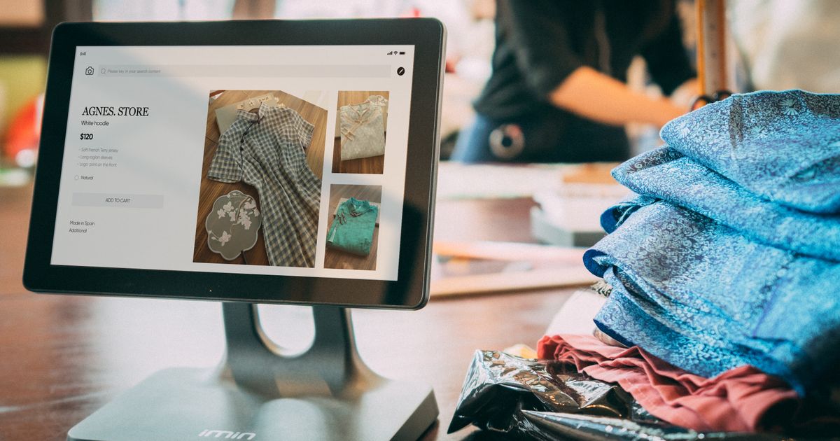 Digital point-of-sale tablet showing a product listing in a small clothing boutique