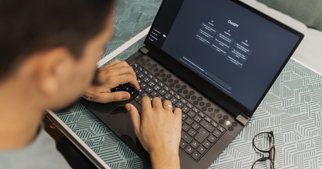 Person typing on a laptop with an AI chat assistant open on the screen
