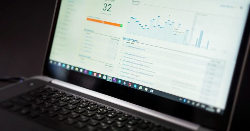 Laptop screen showing a live web analytics dashboard with traffic charts
