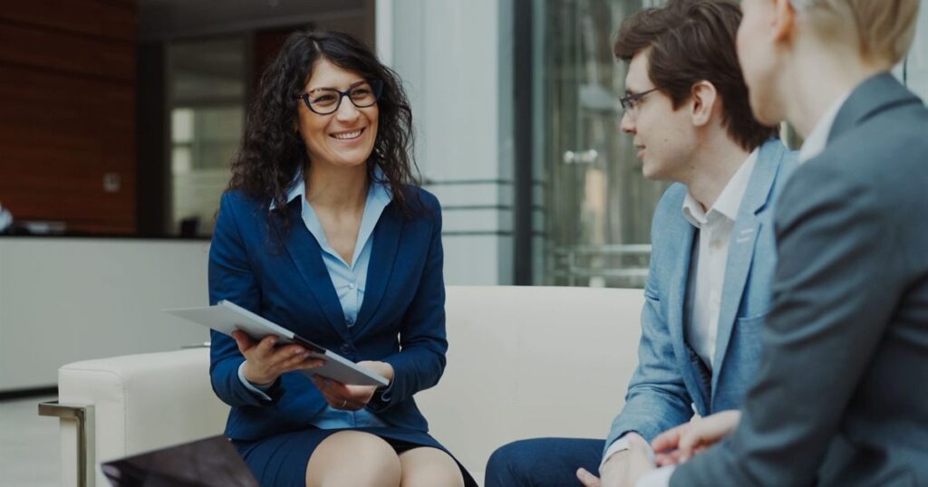 Three colleagues discussing a marketing plan together in an office lounge