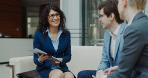 Three colleagues discussing a marketing plan together in an office lounge