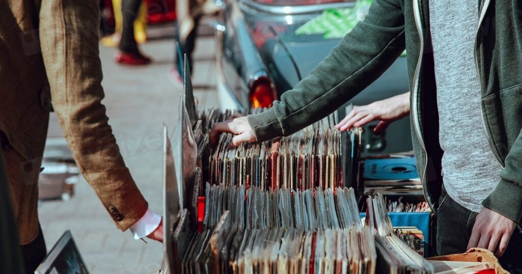 Customers browsing shelves in a small independent record shop, representing the small businesses weighing up AI SEO tools