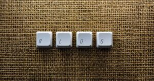 Keyboard keys arranged to spell the word blog on a textured surface.