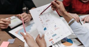 Team reviewing printed marketing charts and reports together at a meeting table