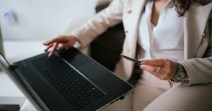 Business owner holding a credit card while paying on a laptop at a home workspace