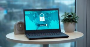 Laptop on a table displaying a padlock and a secured status, representing data protection