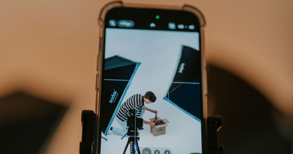 A smartphone mounted on a rig filming a product shoot in a lit studio for short-form video
