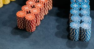 Stacks of red and blue unbranded casino chips on a dark blue gaming table.