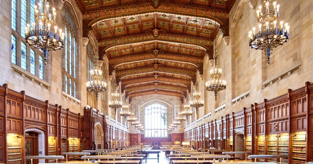 A grand law library reading room lined with bookshelves and hanging chandeliers
