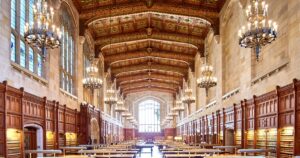 A grand law library reading room lined with bookshelves and hanging chandeliers