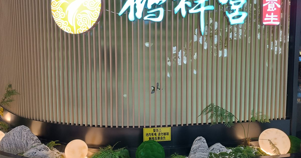 The illuminated sign and screened glass frontage of a foot massage and spa outlet in a shopping mall