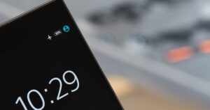 Close-up of a smartphone screen on a desk, the device a customer would use to share a referral code