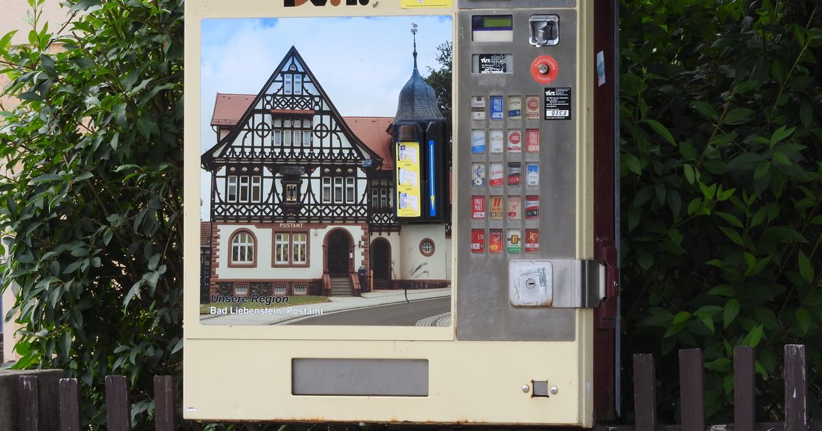 A street-side cigarette vending machine displaying tobacco brand packs and livery, the kind of public brand display Singapore prohibits