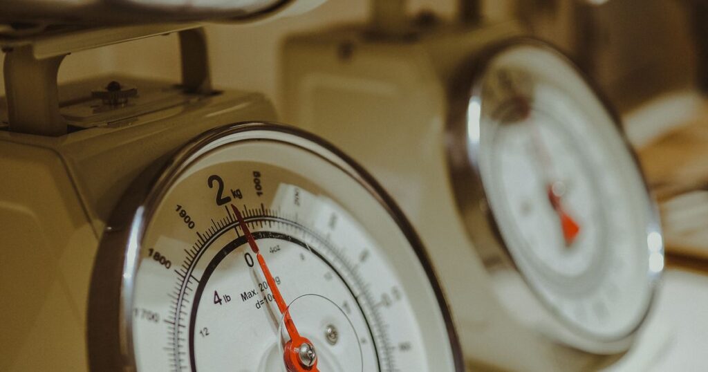 Close-up of an analogue kitchen scale dial marked in kilograms and pounds, illustrating the weights and measures rules for quantity claims in Singapore marketing.