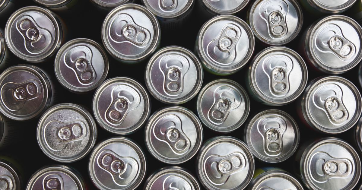 Rows of unbranded silver drink can tops seen from above, illustrating how Singapore's Beverage Container Return Scheme deposit affects how drinks are priced and promoted.