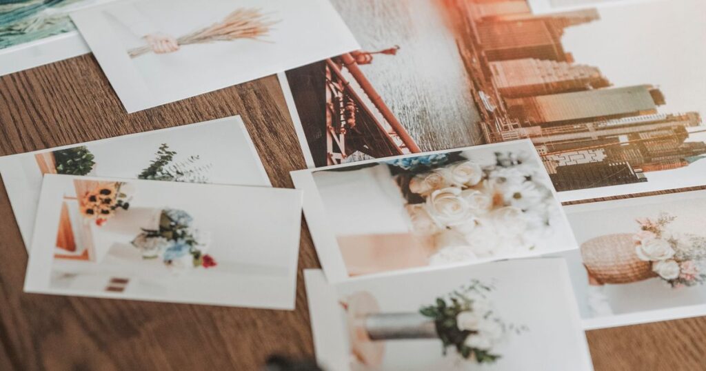 Printed photographs scattered on a wooden table, illustrating the copyright rules for using other people's images in Singapore marketing.