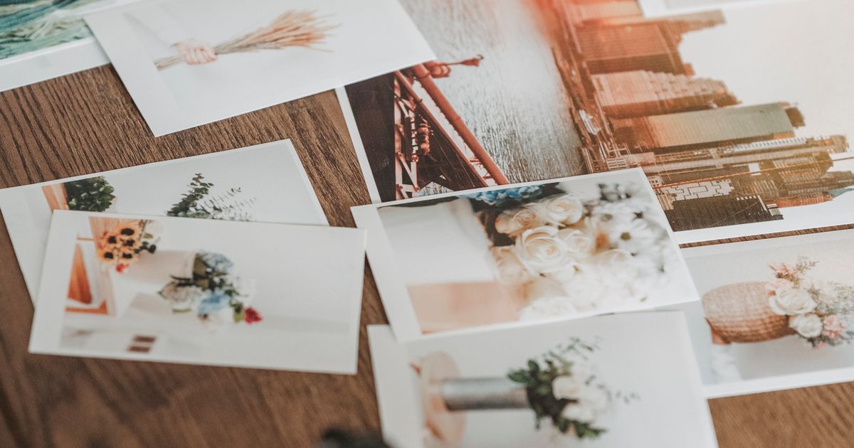 Printed photographs scattered on a wooden table, illustrating the copyright rules for using other people's images in Singapore marketing.