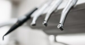Stainless steel dental handpieces hanging from a dental unit in a bright clinic, illustrating the rules on advertising dental services in Singapore.