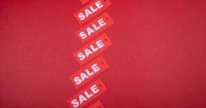 A diagonal row of red SALE price tags on a red background, illustrating the rules on displaying GST-inclusive prices in Singapore advertising.