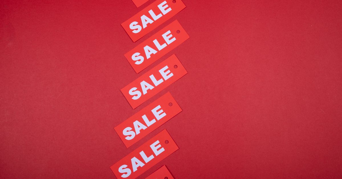 A diagonal row of red SALE price tags on a red background, illustrating the rules on displaying GST-inclusive prices in Singapore advertising.